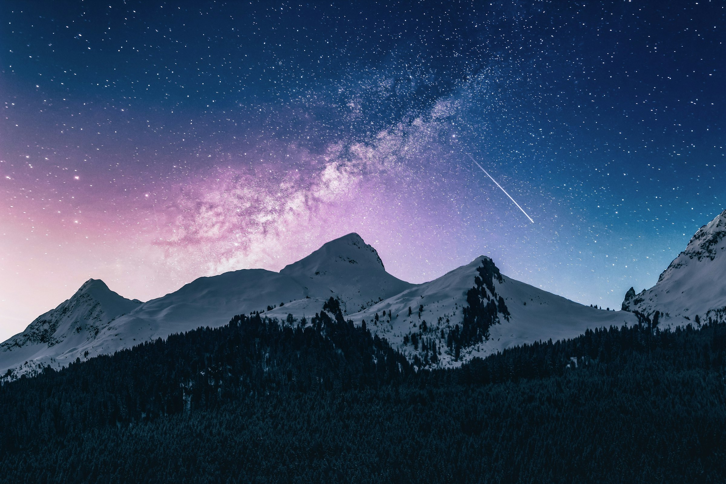 A snow ridge under a violet night sky